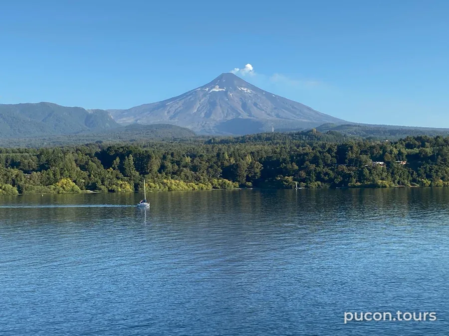 Villarrica volcano above the lake, with a sailboat, seen from Pucón